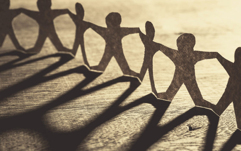 Human chain paper with light and shadow on wood table